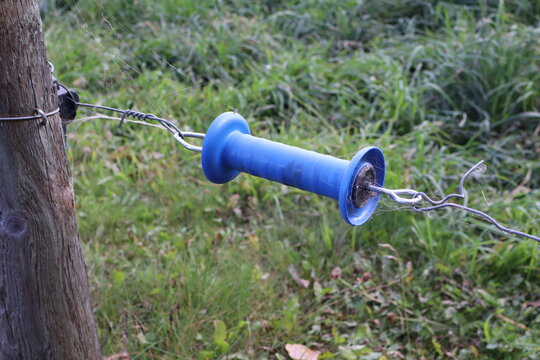 An insulated electric fence gate handle. It allows a person to safely open and close a section of an electric fence without receiving an electrical shock. heavy plastic body insulates the user's hand 