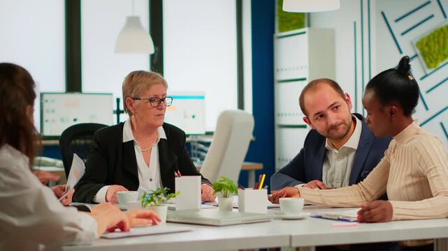 Handshake, agreement and partnership with business colleagues confirming a deal after reviewing documents at a conference table, for negotiation, trust, cooperation and professional commitment.
