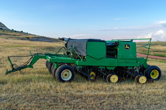 North Dakota, USA - August 23, 2026: A John Deere Grain Drill with a rain tarp in a farm field