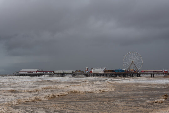 Central Pier and Ferris wheel surrounded by stormy sea surf