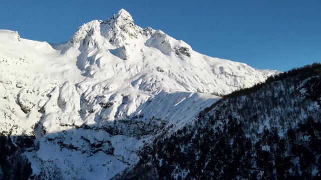 Impresionante pico del Cerro Quinquilil o Colmillo del Diablo, majestuosa monta&ntilde;a nevada bajo un cielo azul profundo en los Andes.