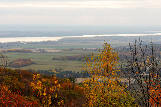 Autumn foliage and rural valley with river horizon. Lookout in Gatineau Park, Quebec, Canada.