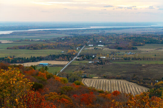 Panoramic high angle view of autumn countryside valley with road, fields and river during sunset. Champlain Lookout in Gatineau Park, Quebec, Canada