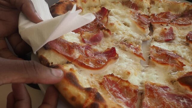 Hand Pulling a Fresh Slice of Authentic Italian Wood Fired Pizza with Melting Mozzarella Cheese Strings Close Up
