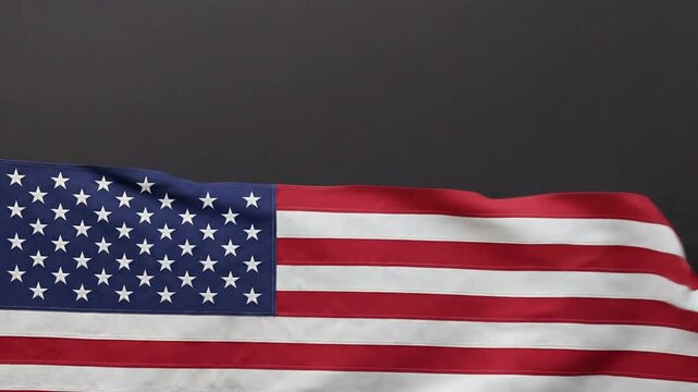 Waving national flag with stars and stripes on dark grey background