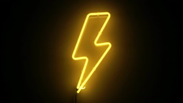 Yellow neon lightning bolt glowing on dark black background. Electricity, energy and power symbol for modern technology, storm and creative illumination concept
