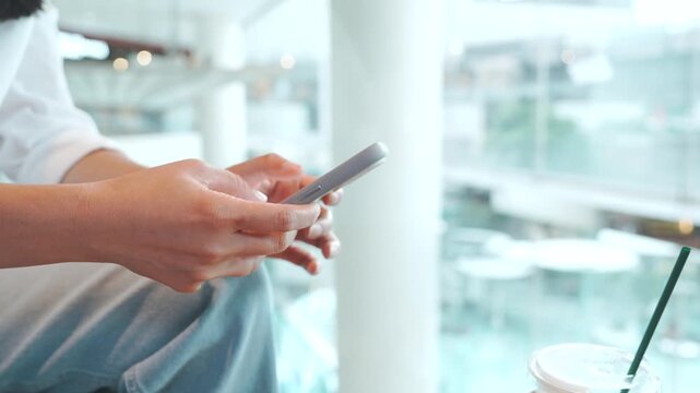 Woman using smartphone and drinking iced coffee at cafe, urban lifestyle, mobile communication, freelance remote work, online browsing and relaxing coffee break during leisure time in the city.