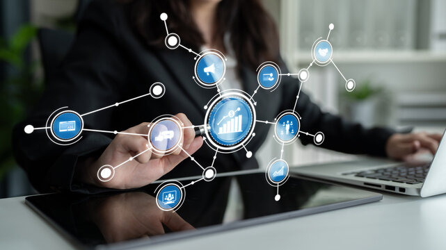 A professional woman engages with a digital interface displaying growth metrics and interconnected data in a modern office setting, symbolizing innovation and connectivity. Crux