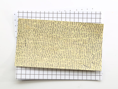 Beige patterned scrapbook paper layered on graph paper for vintage journaling and creative crafts.