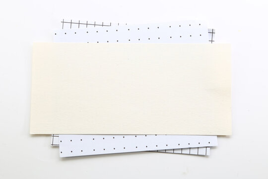 Blank cream paper card layered on dotted sheets for elegant stationery mockups and minimalist designs.