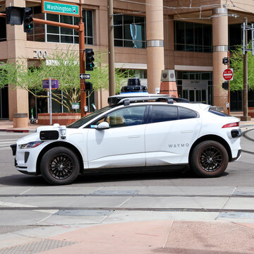 White Waymo Self Driving Autonomous Robotaxi Vehicle Driving at Street Intersection in Downtown Phoenix Arizona, Autonomous Driving Technology Car Side Profile
