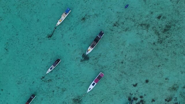 Aerial view of traditional wooden boats floating on clear turquoise water in the Karimunjawa archipelago, Karimunjawa, Central Java, Indonesia.
