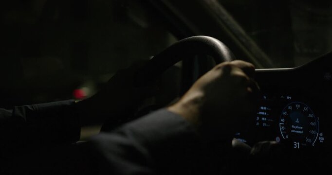 The police officer patrols the street at night by car