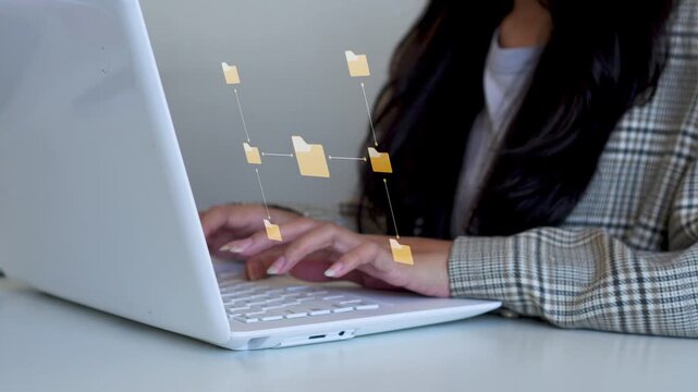 Businesswoman typing on laptop while managing central folder network and digital asset hierarchy