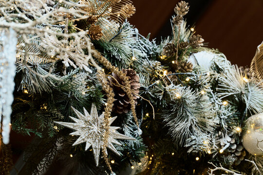 Silver Christmas Star Ornament Sparkles Among Frosted Pine Branches