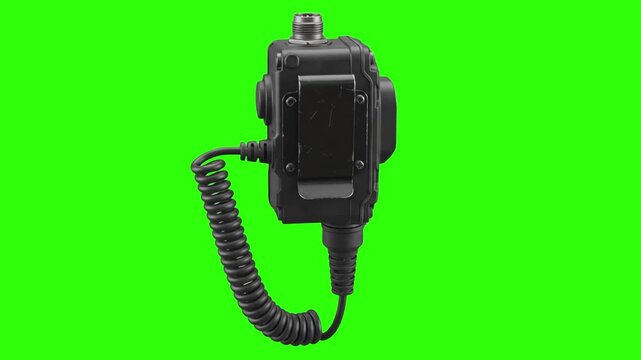 Tactical radio push-to-talk (PTT) module with coiled cable and mounting clip isolated on a studio chroma key green background. Excellent for military comms gear promos, police communication videos, ta