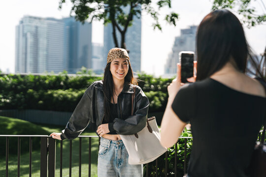 Happy two young asian woman gen z sisters using smartphone taking photo sibling share travel moment on social media engagement
