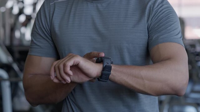 Man Adjusting Fitness Watch During Gym Workout With Trainer Monitoring Exercise, Sport Performance, Fitness Training, Athlete Preparation, Focused Precision In Modern Exercise Facility