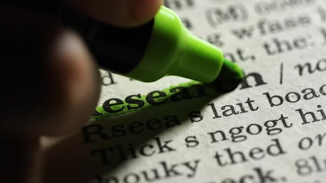 Close-up of a hand highlighting the word search in a dictionary with a green marker, emphasizing research and information retrieval.