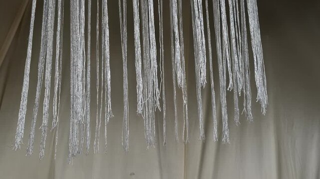 Shimmering metallic thread fringe moving in wind, sparkling silver tassel curtain transition overlay, 60fps 4K video