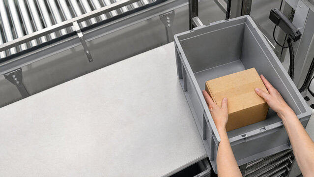 Hands placing an item into a storage tote