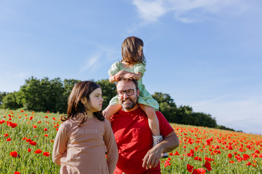 Loving Dad Giving Piggyback Ride to Child in a Wildflower Meadow
