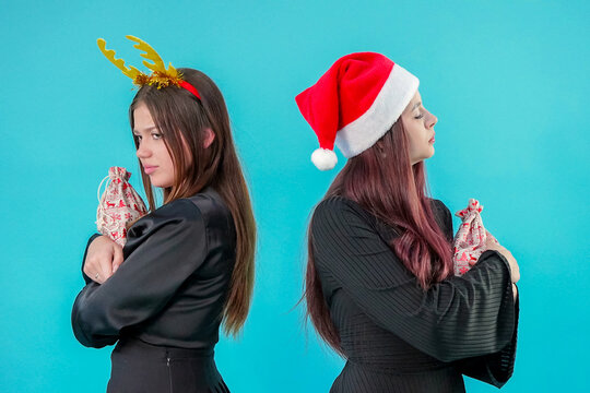 Offended Young Women Holding Christmas Gift Bags and Turning Away