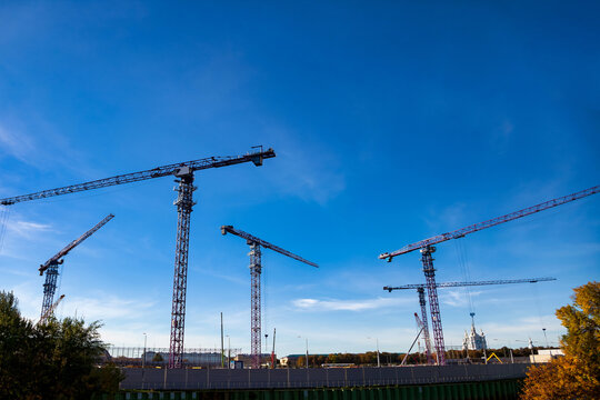 Construction Site With Cranes and Blue Sky in Outdoor Setting