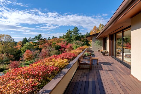 秋の美しい紅葉と広々としたウッドデッキのある家屋