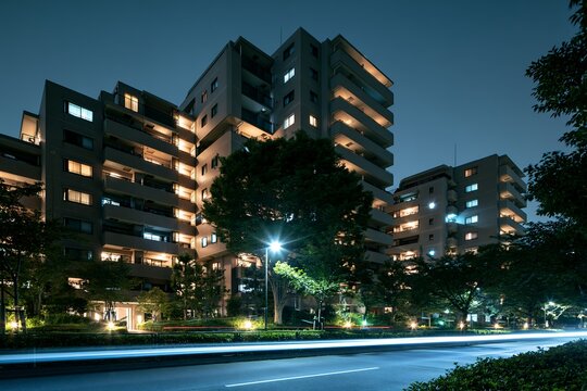 夜の都会に佇むマンション群と光の軌跡