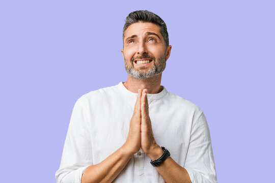 Man caucasian gray hair beard casual clothes begging praying beg pray hope hands together expression emotional studio portrait &mdash; bearded man pleading, hopeful, desperate, hands clasped