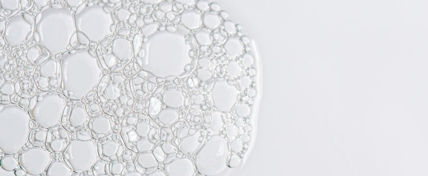 The texture of the foam of shower gel or soap suds or shaving foam. Cosmetic skin care product. Macrophotography. Copy space