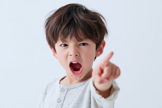 怒りながら指差し大声で叫ぶ子供のアップ