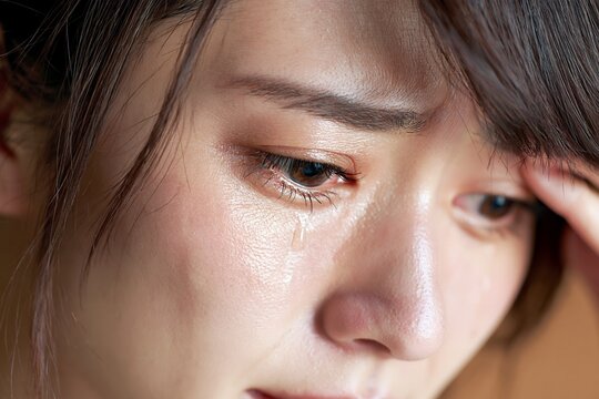 涙を流して悲しむ女性の表情に共感するクローズアップ