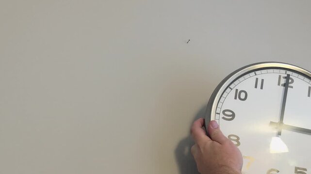 Changing wall quartz clocks to winter time by setting back one hour for daylight saving adjustments