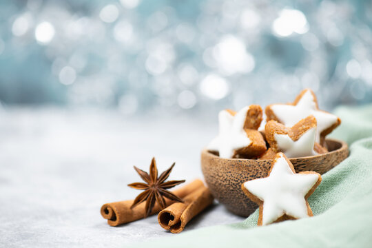 Christmas holiday sweets, homemade cinnamon stars with hazelnuts and almonds, cookies and biscuits with icing glaze, bokeh light 
