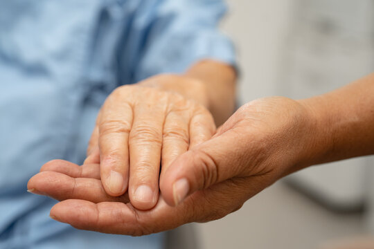 Caregiver holding hands Asian elderly woman patient, help and care in hospital.