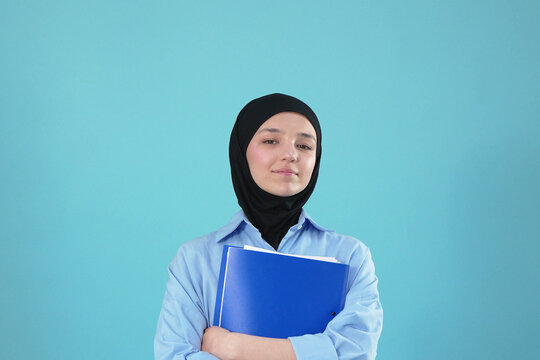 Young Muslim Female Student Wearing Black Hijab and Holding Blue Folder