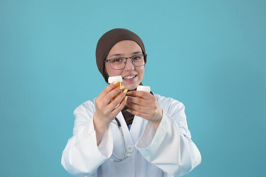 Friendly Muslim Female Doctor Showing Two Pill Bottles