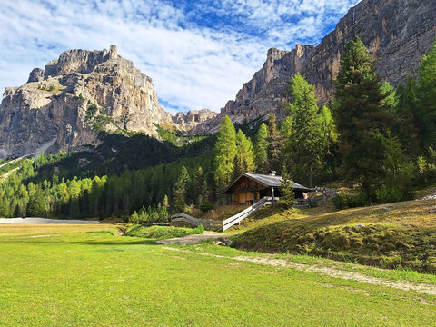 The winding Vallunga hiking trail among the rocks with a mountain refuge in the Puez Geisler nature park in Selva.