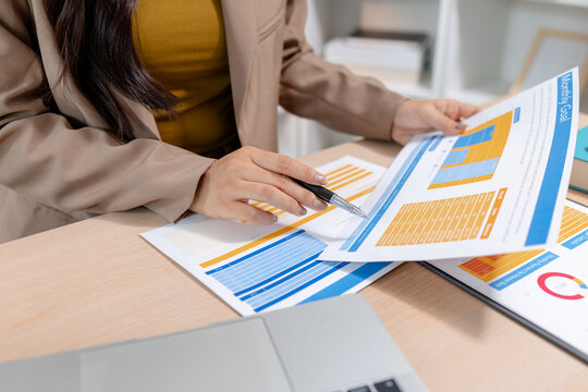 Business professional reviewing financial reports, analyzing performance data and supporting strategic planning in a modern office, representing business management