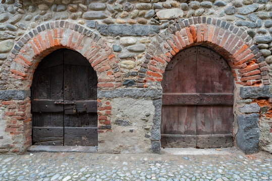 Italia, Ricetto di Candelo. Panorama di borgo medievale. Storia e cultura di Italia e d'Europa. Porta in legno isolata in primo piano.