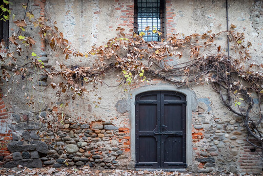 Italia, Ricetto di Candelo. Panorama di borgo medievale. Storia e cultura di Italia e d'Europa. Porta in legno isolata in primo piano.