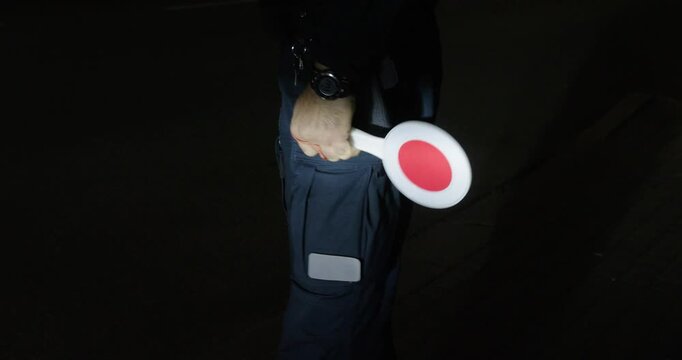 A police officer is working on the street with a breathalyzer