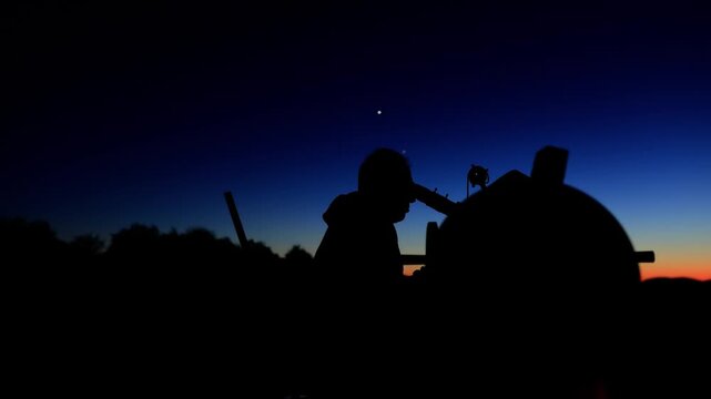 Amateur astronomer observing stars, planets, Moon and other celestial objects with a telescope in nature.