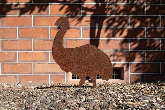 Rustic Metal Bird Sculpture Against Brick Wall