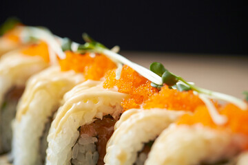 Gourmet Japanese Fusion California roll with spicy mayo drizzle, orange tobiko flying fish roe, and microgreen garnish © mnimage