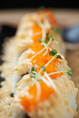 Gourmet Japanese Fusion California roll with spicy mayo drizzle, orange tobiko flying fish roe, and microgreen garnish © mnimage