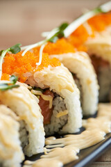 Gourmet Japanese Fusion California roll with spicy mayo drizzle, orange tobiko flying fish roe, and microgreen garnish © mnimage