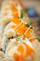 Gourmet Japanese Fusion California roll with spicy mayo drizzle, orange tobiko flying fish roe, and microgreen garnish © mnimage